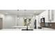 Open kitchen with an island, white cabinetry, stainless steel appliances, and modern pendant lighting at 5709 N 20Th St, Tampa, FL 33610
