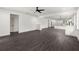 Open-concept living room with dark hardwood floors connecting to the kitchen area with white cabinets at 5709 N 20Th St, Tampa, FL 33610