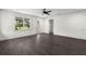 Open-concept living room featuring dark wood floors, white walls, and ample natural light from large windows at 5709 N 20Th St, Tampa, FL 33610