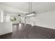 Open-concept living room with modern lighting, high ceilings, and dark wood floors at 5709 N 20Th St, Tampa, FL 33610