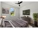 Cozy main bedroom with neutral tones, a leafy green plant, dresser, and an outside view at 5709 N 20Th St, Tampa, FL 33610