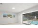 Sunlit bedroom with pool access, large window, white tiled floor, and serene outdoor views at 6236 17Th S St, St Petersburg, FL 33712