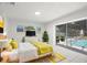 Bright bedroom with a sliding glass door to the pool, white tile flooring, and yellow accents at 6236 17Th S St, St Petersburg, FL 33712