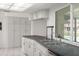 Clean and efficient kitchen with stainless appliances, white cabinets and black countertops overlooking the backyard pool at 6236 17Th S St, St Petersburg, FL 33712