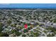 Extensive aerial shot focusing on a neighborhood near coastal waters, indicated by a vibrant red location pin at 6554 34Th N Ave, St Petersburg, FL 33710