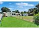 Spacious backyard with lush lawn, storage shed, fenced perimeter, and tropical palm trees at 6554 34Th N Ave, St Petersburg, FL 33710