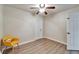 Neutral toned bedroom with modern ceiling fan, wood-look floors, and a bright yellow chair at 6554 34Th N Ave, St Petersburg, FL 33710