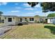 Charming single-story home featuring a well-maintained lawn, bright facade, and clear windows at 6554 34Th N Ave, St Petersburg, FL 33710