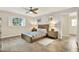 Serene bedroom with neutral tones, ceiling fan, tile floors, and a window with natural light at 6561 Exeter Ct, Seminole, FL 33772