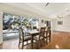 Dining room with hardwood floors, a large table for six, and views of the backyard pool area at 6561 Exeter Ct, Seminole, FL 33772
