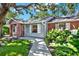 Inviting home entrance with brick accents, lush landscaping, and a pathway leading to the front door at 6561 Exeter Ct, Seminole, FL 33772