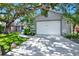 Home exterior featuring a well-maintained garage, driveway, and charming front lawn with palm trees at 6561 Exeter Ct, Seminole, FL 33772