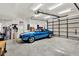 Spacious garage featuring a classic blue car and an automatic garage door at 6561 Exeter Ct, Seminole, FL 33772