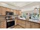 Bright kitchen featuring stainless steel appliances, granite countertops, and a view of the backyard pool at 6561 Exeter Ct, Seminole, FL 33772