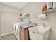 Well-equipped laundry room with washer, dryer, sink, and storage shelves at 6561 Exeter Ct, Seminole, FL 33772