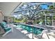 Relaxing screened-in pool area with dining table and chairs near the water at 6561 Exeter Ct, Seminole, FL 33772