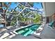 Inviting screened-in pool area with a large tree providing shade and a glimpse of the lake at 6561 Exeter Ct, Seminole, FL 33772
