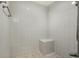 All-white tiled shower with a built-in seating area at 6561 Exeter Ct, Seminole, FL 33772