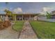 Lush backyard featuring a stone walkway, covered patio, and mature landscaping, creating a serene outdoor space at 735 123Rd Ave, Treasure Island, FL 33706