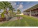 Lush backyard featuring a fire pit, tropical landscaping, and covered patio with waterfront views at 735 123Rd Ave, Treasure Island, FL 33706