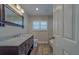 Traditional bathroom features a wood vanity with granite countertop, framed mirror and tiled walk-in shower at 735 123Rd Ave, Treasure Island, FL 33706
