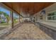 Spacious covered patio with ceiling fans, wood ceiling, and stone column accents at 735 123Rd Ave, Treasure Island, FL 33706