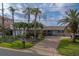 Charming single-story home with lush landscaping, brick driveway, and inviting front entrance at 735 123Rd Ave, Treasure Island, FL 33706