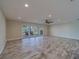 Bright living room with wood-look floors, ceiling fan, and sliding glass doors to the patio at 735 123Rd Ave, Treasure Island, FL 33706