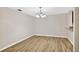 Dining space featuring wood-look floors, neutral walls, and a modern chandelier at 7821 Niagara Ave # 2102, Tampa, FL 33617