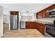 Bright kitchen with wood floors, wood cabinets, granite countertops, and stainless steel appliances at 7821 Niagara Ave # 2102, Tampa, FL 33617
