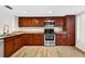 The kitchen features wood floors, wood cabinets, stainless steel appliances, and granite countertops at 7821 Niagara Ave # 2102, Tampa, FL 33617