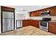 Well-lit kitchen featuring wood floors, wood cabinets, stainless steel appliances, and granite countertops at 7821 Niagara Ave # 2102, Tampa, FL 33617