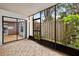 Enclosed lanai featuring tiled flooring, lush foliage views, and a glimpse of the adjacent kitchen at 7821 Niagara Ave # 2102, Tampa, FL 33617