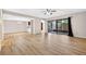 Open living room with wood-look tile flooring, sliding glass doors to the outdoors, and neutral paint at 7821 Niagara Ave # 2102, Tampa, FL 33617