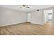 Neutral living room with wood-look floors, a ceiling fan, and natural light from a doorway at 7821 Niagara Ave # 2102, Tampa, FL 33617