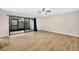 Living room with wood-look floors and sliding glass doors leading to a screened-in porch at 7821 Niagara Ave # 2102, Tampa, FL 33617