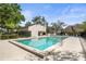 Community pool surrounded by lounge chairs and mature trees for relaxing and recreation at 7821 Niagara Ave # 2102, Tampa, FL 33617