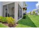 Lawn with Screened porch, adjacent to green space with mature trees and shrubbery at 803 Oak Bend Ln, Dunedin, FL 34698