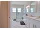Well-lit bathroom features a glass shower, sleek marble tile, dual sink vanity, and sophisticated mirrors for a modern touch at 803 Oak Bend Ln, Dunedin, FL 34698