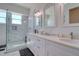 Elegant bathroom showcasing a glass shower, marble tile, dual sink vanity, and decorative mirrors for a luxurious feel at 803 Oak Bend Ln, Dunedin, FL 34698