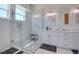 Bright bathroom featuring a glass shower, marble tile, dual sink vanity, and contemporary mirrors for a spa-like experience at 803 Oak Bend Ln, Dunedin, FL 34698