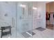 Modern bathroom with a glass shower, dual sink vanity, and a view into a walk-in closet for added convenience at 803 Oak Bend Ln, Dunedin, FL 34698