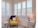 Sun-filled bedroom with light-blocking shutters and a decorative yellow chair at 803 Oak Bend Ln, Dunedin, FL 34698