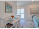 Cozy dining area features vintage table with seating for two, beachy art, and shuttered sliding door at 803 Oak Bend Ln, Dunedin, FL 34698