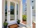 Stylish front entrance features glass door, potted plants, and neutral color scheme at 803 Oak Bend Ln, Dunedin, FL 34698