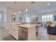 Open concept kitchen features island with seating, stainless steel dishwasher, and view of the living room at 803 Oak Bend Ln, Dunedin, FL 34698