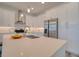 Bright kitchen with stainless appliances, white cabinetry, island with quartz countertops, and modern pendant lighting at 803 Oak Bend Ln, Dunedin, FL 34698