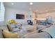 Open-concept living space with gray sofas, a vintage coffee table, and a view to the bright kitchen at 803 Oak Bend Ln, Dunedin, FL 34698