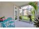 Cozy screened porch with blue chairs and table, perfect for relaxing outdoors at 803 Oak Bend Ln, Dunedin, FL 34698