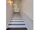 Ascending staircase features white risers and dark wood treads, complemented by a white handrail and white walls at 803 Oak Bend Ln, Dunedin, FL 34698